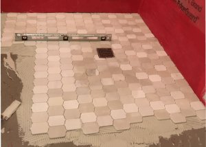 tiles being installed over a DCM-PRO underfloor heating system.