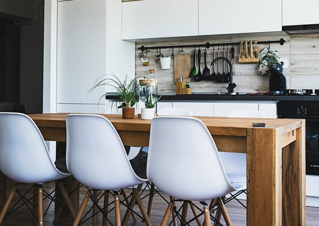 Kitchen with table, chairs, sink, oven, and stove.