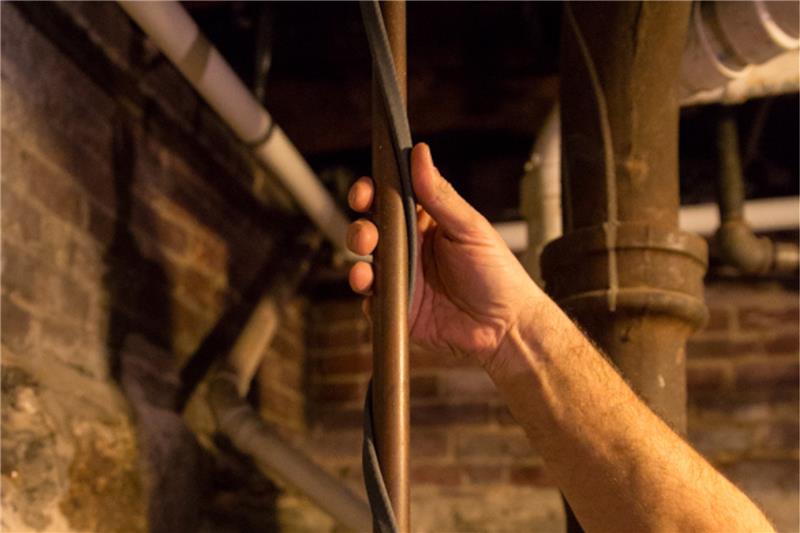 A man installing Warmup's self-regulating cable on a pipe.a