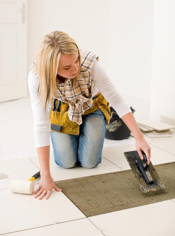 Woman installing underfloor heating.
