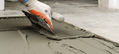 installer scraping cement onto floor